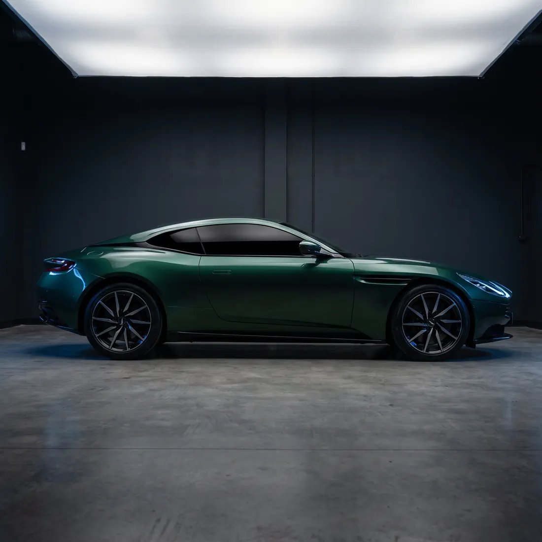 Coupé vert vu de profil, toutes les vitres latérales teintées et opaques